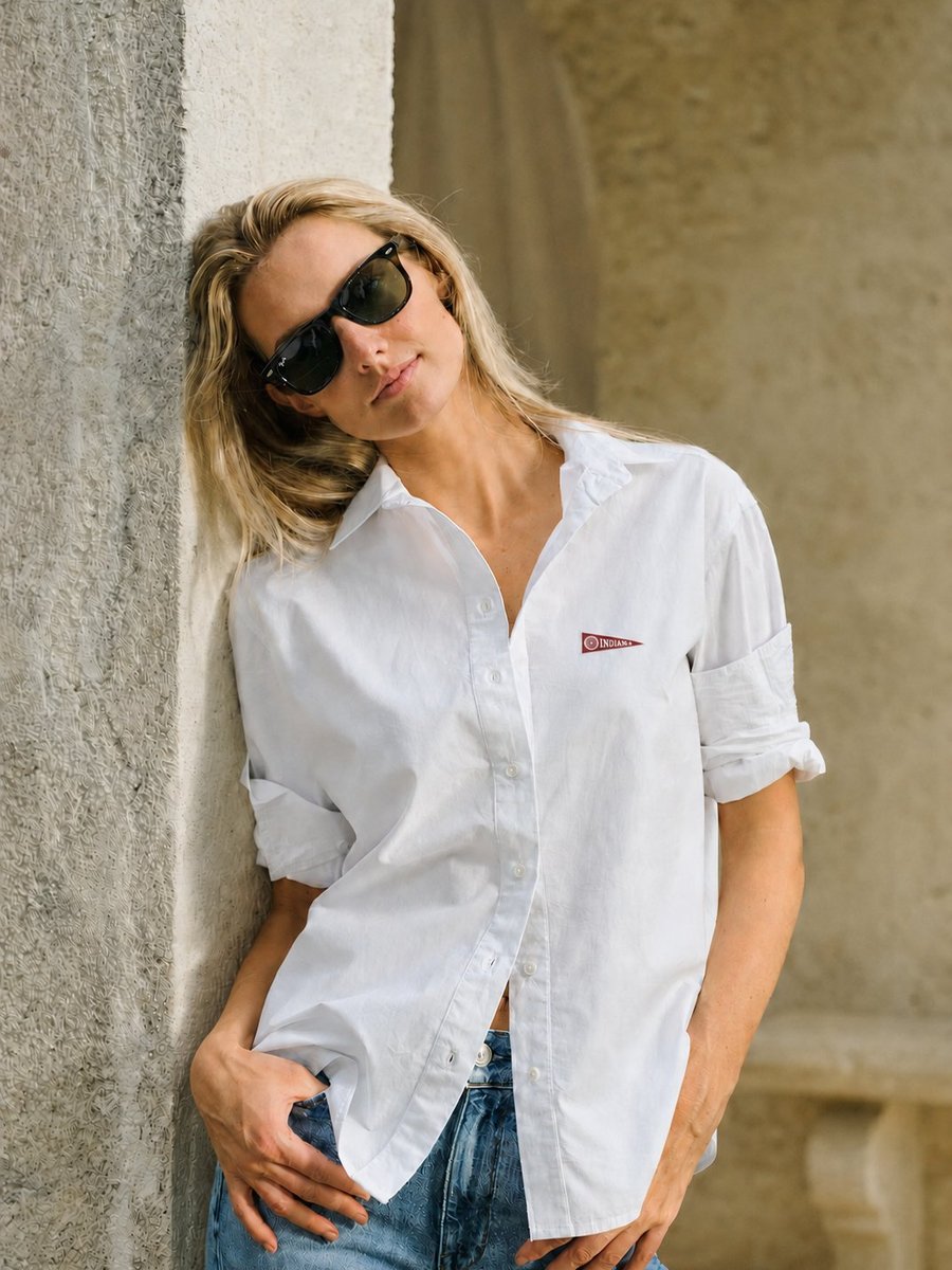 Woman wearing a white poplin button-down shirt with an Indiana pennant patch at the chest.