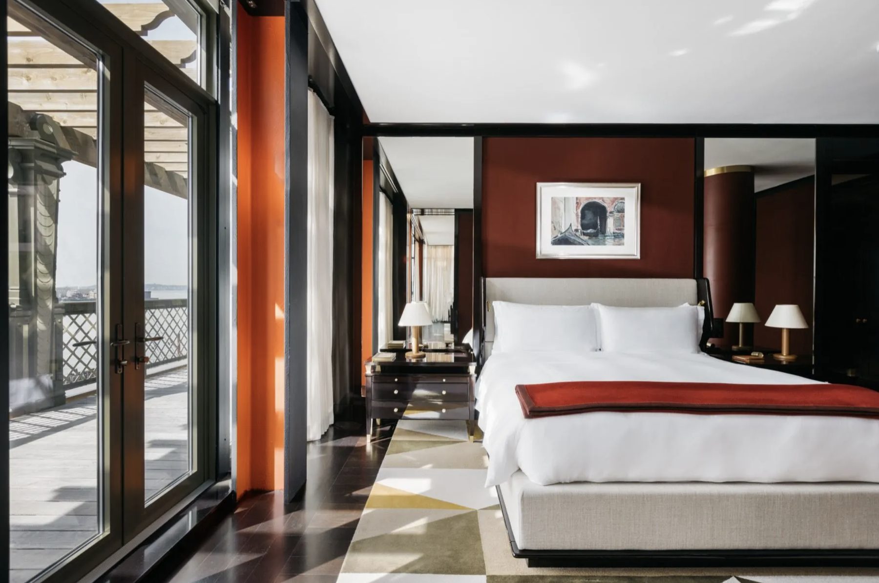 The penthouse — a light-filled bedroom opening to a private rooftop terrace with skyline views.